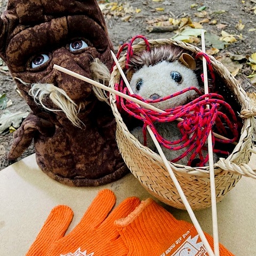 Foto von einem Stofftier-Igel, der verheddert in einer Schnur in einem Körbchen liegt. Daneben Kinderhandschuhe zum Müll aufsammeln