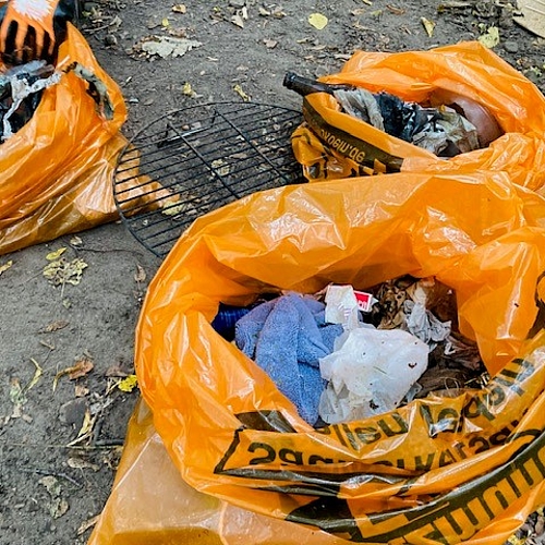 Drei große organge Müllsäcke voller Müll, der aufgesammelt wurde